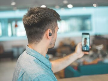 shallow focus photo of man in gray collared top taking selfie