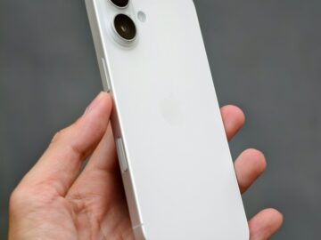 A person holding a white iPhone in their hand