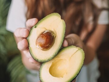 sliced avocado fruit on persons hand
