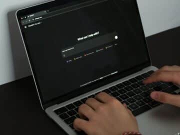 A person typing on a laptop on a table