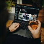 A person sitting on a couch with a laptop