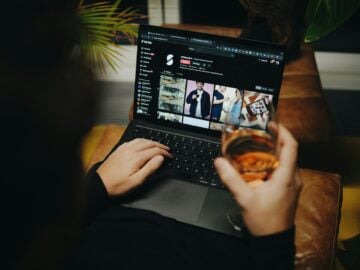 A person sitting on a couch with a laptop