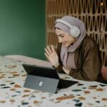 a person sitting on a table with a laptop