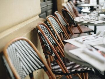 Outdoor cafe chairs and tables await diners.
