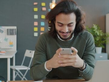 Man smiling while looking at his smartphone