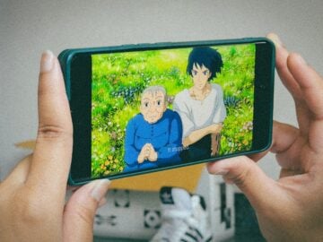 A person holding up a cell phone to take a picture