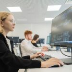 a woman sitting in front of a computer monitor