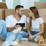 Couple looking at phone surrounded by moving boxes