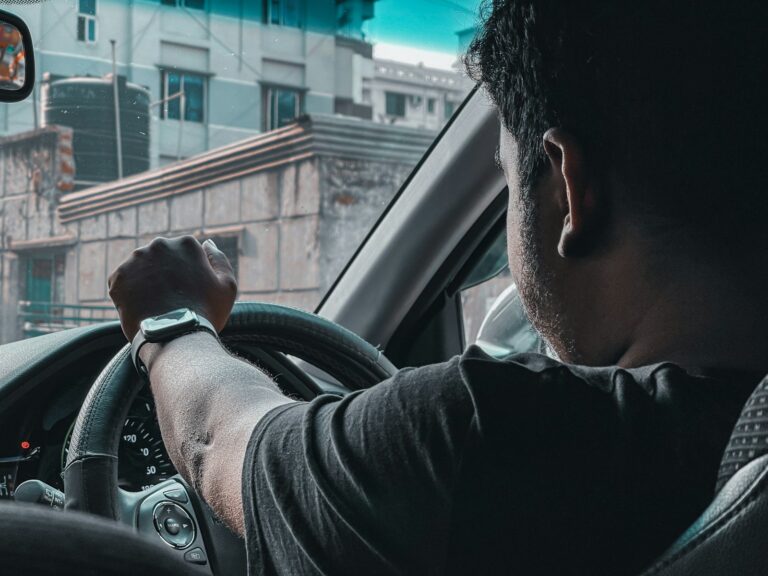 man in black shirt driving car during daytime