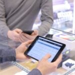 two people are looking at a tablet in a store