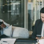 Two businessmen using devices in a modern office.