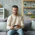 Man playing video games on a couch