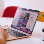 A woman sitting at a table using a laptop computer