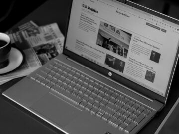 Stay Informed with Irishbreakingnews com 11 a laptop computer sitting on top of a desk next to a cup of coffee