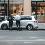 two police officers standing on the back of a car