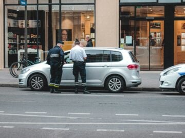 two police officers standing on the back of a car