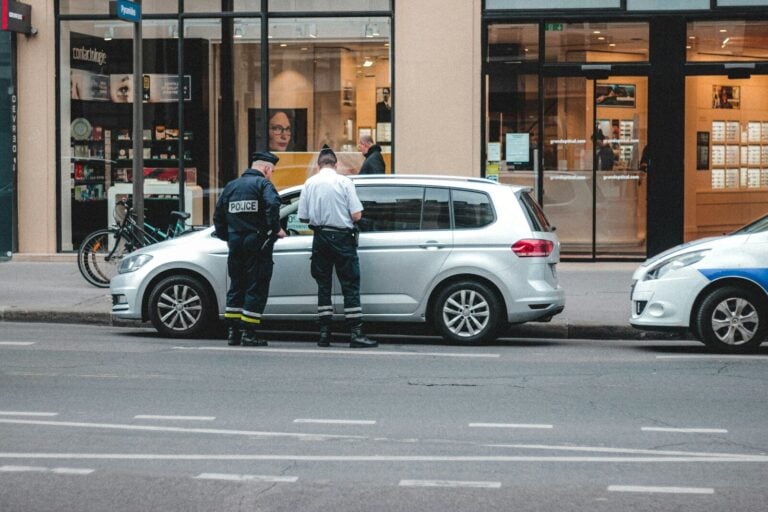 two police officers standing on the back of a car