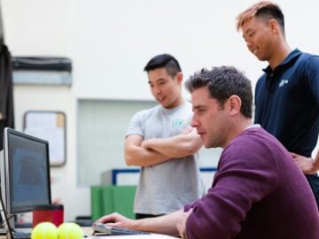 man in maroon long sleeve shirt holding a book