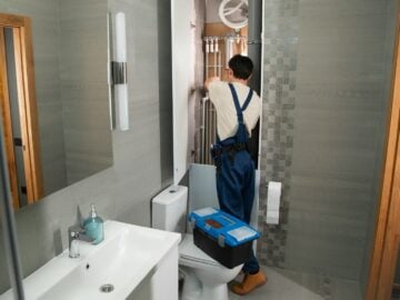 A plumber repairs plumbing in a bathroom.