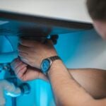 a man fixing a water heater in a room