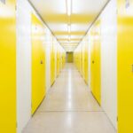 A long hallway with yellow doors on both sides.
