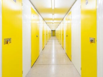 A long hallway with yellow doors on both sides.