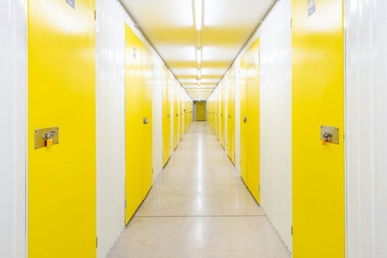 A long hallway with yellow doors on both sides.