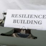 a typewriter with a sign that reads resilince building