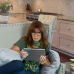 a woman sitting in a chair with a tablet