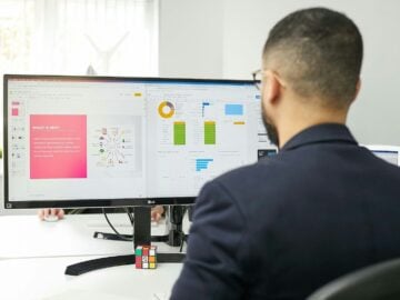 a man sitting at a desk looking at a computer screen