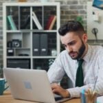 a man sitting in front of a laptop computer