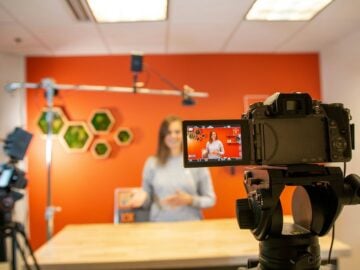black video camera on brown wooden table