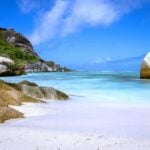 a large rock sitting on top of a sandy beach