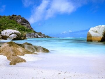 a large rock sitting on top of a sandy beach