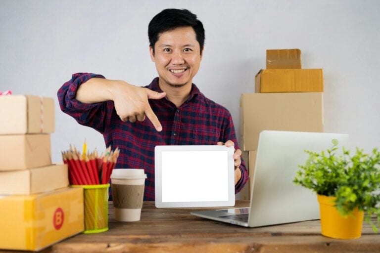 a man pointing at a laptop screen on a desk