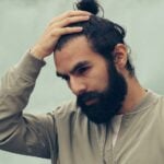 man holding his black hair